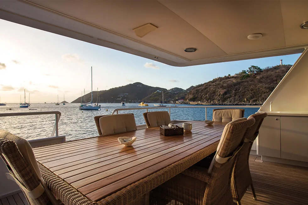 Broward 100 aft deck dining table at sunset