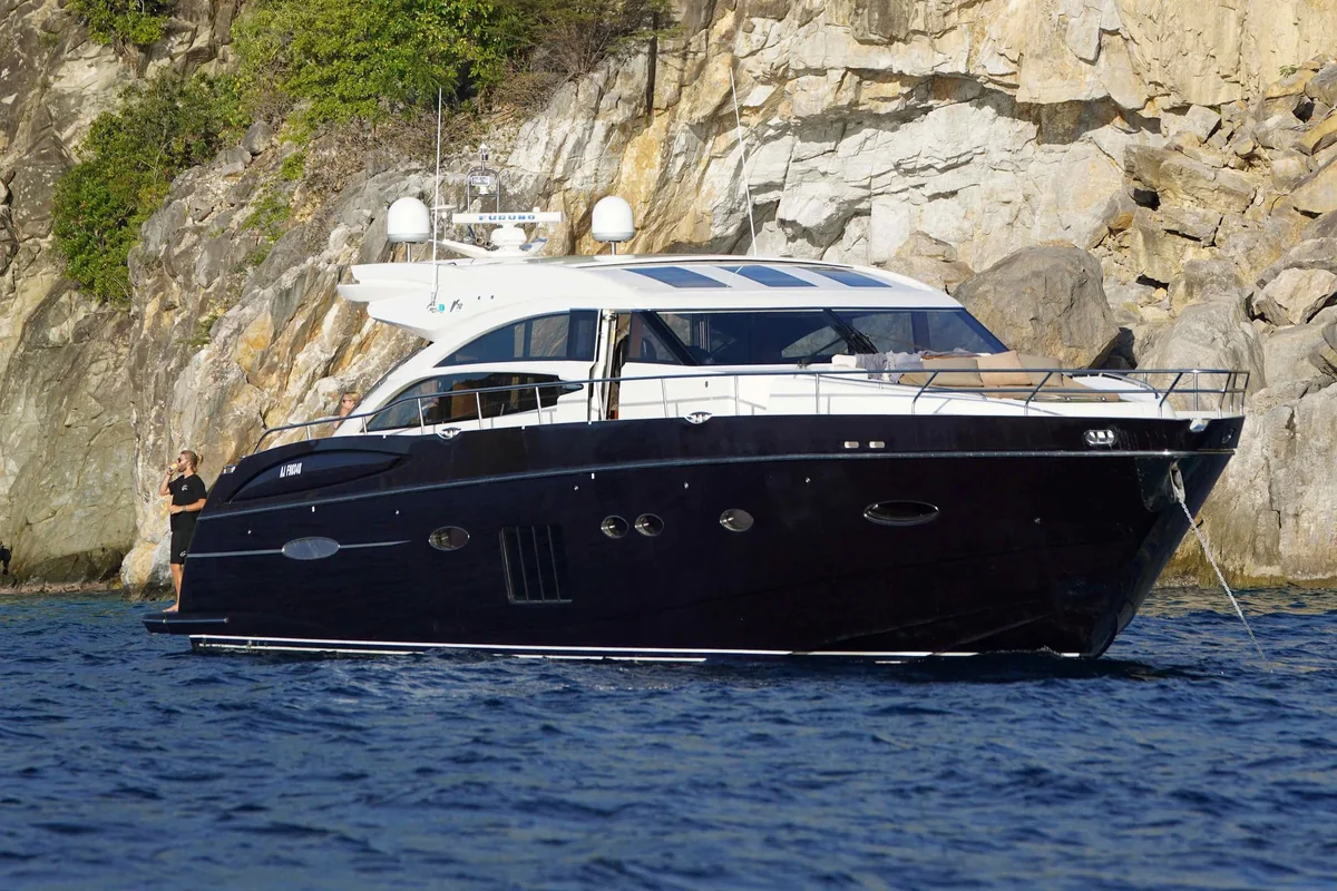Princess 72 navy-hulled motor yacht at anchor below the cliffs